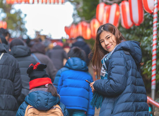 Woman is walking into Japanese New year festival in Sendai Osaki Hachimangu Shrine