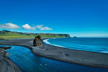 Famous Dyrholaey rock formations and black sand beach near Vik Iceland on sunny day