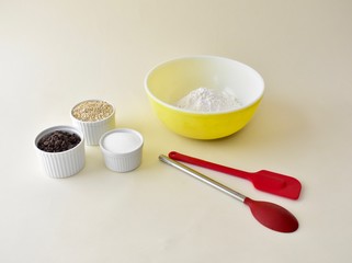 Baking ingredients with mixing bowls and kitchen utensils for making pastries and cookies
