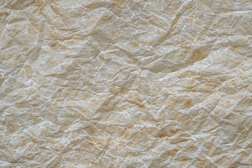 Close up old crumpled beige parchment paper.