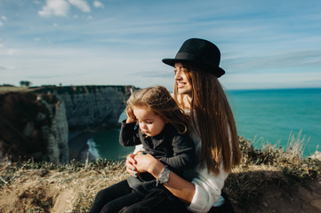 A beautiful young family on the sandy shore of the ocean relaxing and have a fun