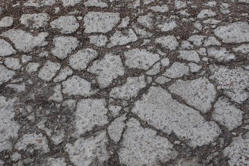 gray stone texture of asphalt pieces with cracks on the road
