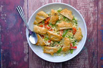 Homemade nuggets with salad on plate on wooden table.