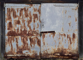 Gray metal double door, old garage door, paint peeling off