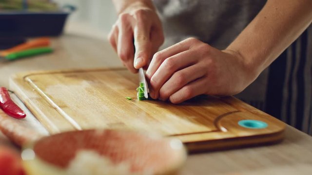Close Up Footage of a Man Chopping a Green Spring Onion with a Sharp Kitchen Knife
