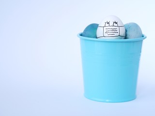 Easter eggs with a self protection face mask, colored with a natural red cabbage, during a coronavirus outbreak in easter celebration time.