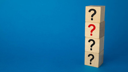 four cubes with question marks of black and one red on a blue background