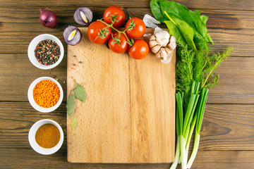 Wooden board with clear space. Around tomato and dill, olive oil, spice, peper, avocado, green...