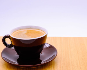 Coffee cup on wooden kitchen table. Top view with morning sunlight