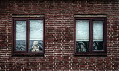 Teddy bear at a window as part of 