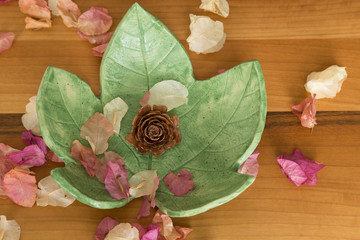 Ceramic leaf plate on the wooden background.