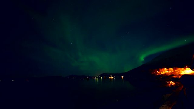time lapse of northern lights seen from the sea shore in norway