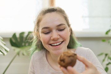 Teenage girl leads culinary vlog, girl shows freshly baked chocolate muffin