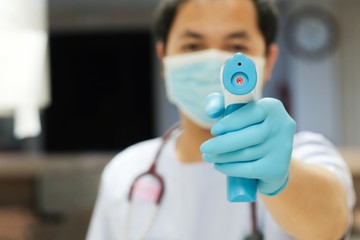 Medical staff use infrared forehead thermometer for check body temperature, Covid-19 outbreak...