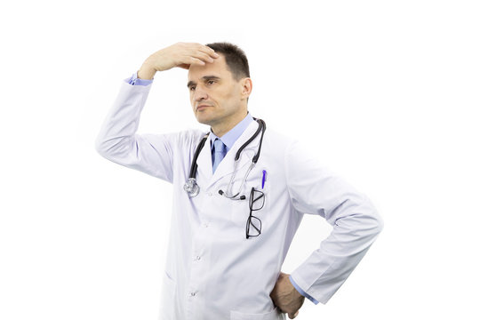 Middle aged surgeon man with glasses in chest pocket wearing medical gown and stethoscope over isolated white background tired hold hands on head feeling fatigue and headache. Stress concept.