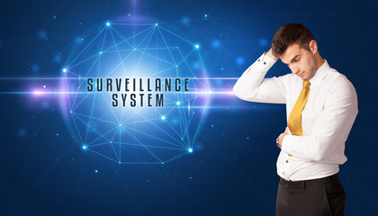 Businessman thinking about security solutions with SURVEILLANCE SYSTEM inscription