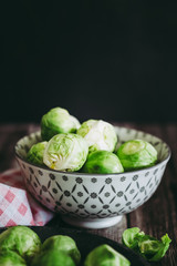 Choux de Bruxelles dans un petit bol céramique posé sur la table en bois en cuisine