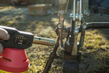 Heating a siezed metal rod on a splined rod or axle, using a three jaw spanner and a propane heater to release the tension and separate two metal objects.