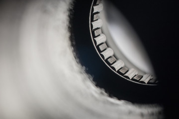 Detail or macro photo of a roller needle bearing installed in a pipe or round orifice. Metal...