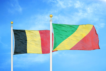 Belgium and Congo two flags on flagpoles and blue cloudy sky