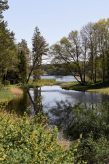 Fototapeta na wymiar Letni, sielankowy widok na jezioro i ogród Pałacu Tyszkiewiczów w Zatroczu - dzielnicy Troków na Litwie