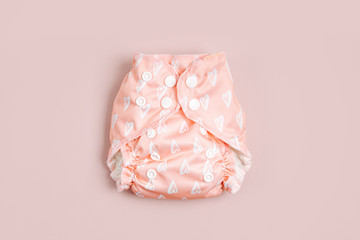 Reusable cloth baby diapers. Eco friendly cloth nappies on a pink background. Sustainable lifestyle. Zero waste concept.