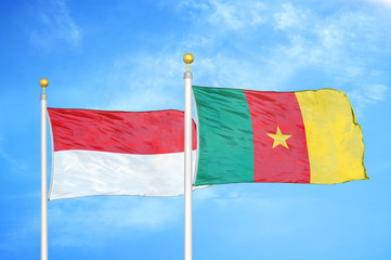 Indonesia and Cameroon two flags on flagpoles and blue cloudy sky