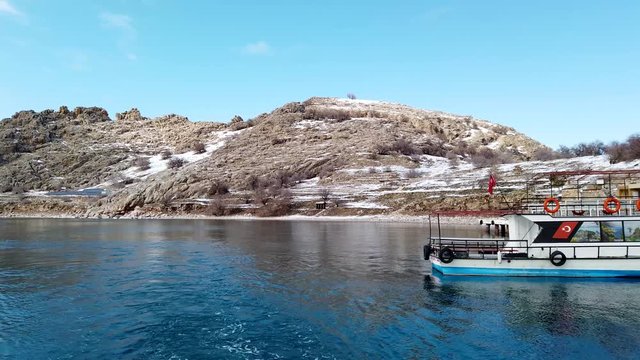 Akdamar island, Van, Turkey - February 2020: Boats and pier of Akdamar island and surp church Akdamar church. It is an important religious place for the Armenian people