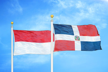 Indonesia and Dominican Republic two flags on flagpoles and blue cloudy sky