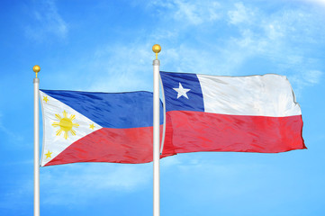 Philippines and Chile two flags on flagpoles and blue cloudy sky