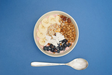 Handmade Bowl healthy tasty breakfast of yogurt, smoothie with granola, nuts, bananas and berries