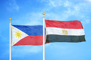 Philippines and Egypt two flags on flagpoles and blue cloudy sky