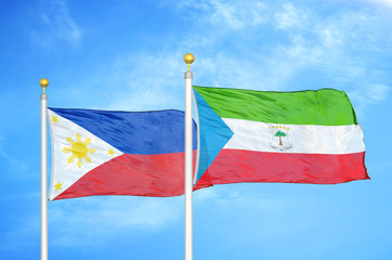 Philippines and Equatorial Guinea two flags on flagpoles and blue cloudy sky