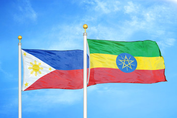 Philippines and Ethiopia two flags on flagpoles and blue cloudy sky