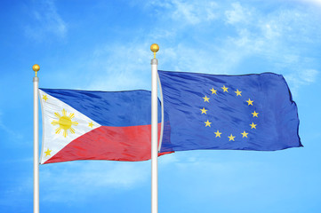 Philippines and European Union two flags on flagpoles and blue cloudy sky