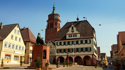 Fototapeta na wymiar schöner alter Marktplatz in Weil der Stadt mit Rathaus, Kirchturm und Kepler Denkmal vor blauem Himmel