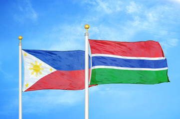 Philippines and Gambia two flags on flagpoles and blue cloudy sky