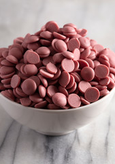 Bowl of Authentic Ruby Chocolate Drops on a Marble Counter