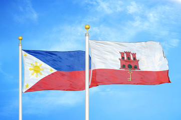 Philippines and Gibraltar two flags on flagpoles and blue cloudy sky