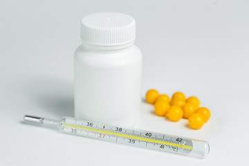 white plastic can with medicines and thermometer