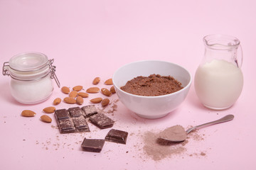 Crema de cacao vegana con ingredientes sobre fondo rosa.