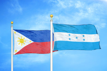 Philippines and Honduras two flags on flagpoles and blue cloudy sky
