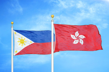 Philippines and Hong Kong two flags on flagpoles and blue cloudy sky