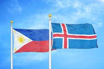 Philippines and Iceland two flags on flagpoles and blue cloudy sky