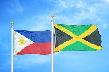 Philippines and Jamaica two flags on flagpoles and blue cloudy sky