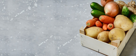 banner fresh organic vegetables on a grey background. carrots, potatoes, zucchini, onions, artichoke. layout copy space .  concept delivery fresh vegetables, recipe salad for  healthy diet