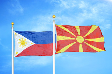 Philippines and North Macedonia two flags on flagpoles and blue cloudy sky