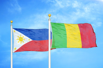 Philippines and Mali two flags on flagpoles and blue cloudy sky