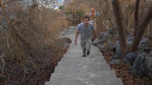 Tracking Shot of Man Hiking Up Stairs in Forest