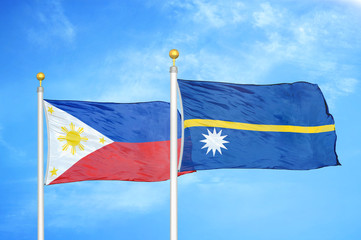 Philippines and Nauru two flags on flagpoles and blue cloudy sky